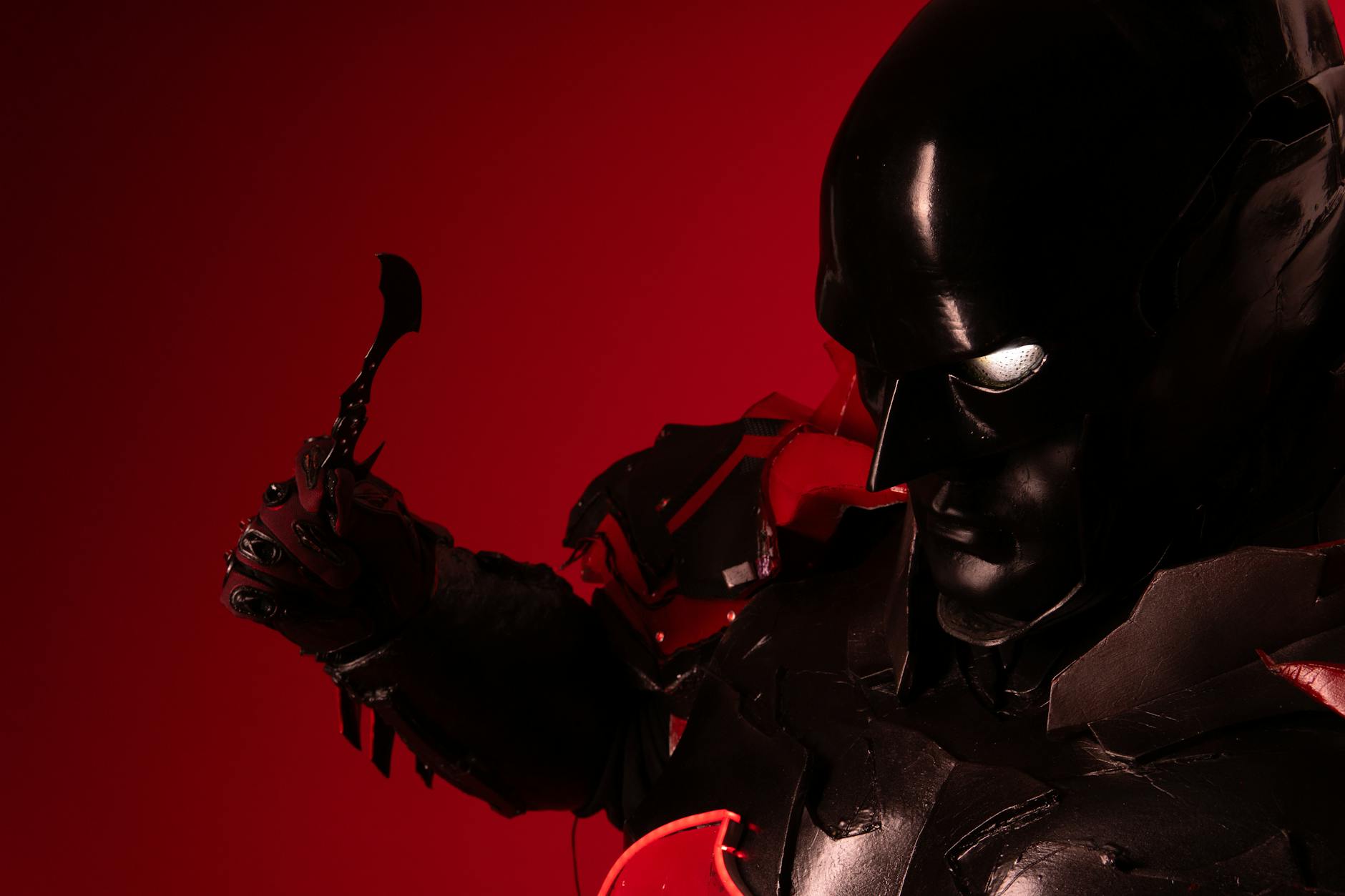 Ciemny cosplay bohatera fantasy na czerwonym tle