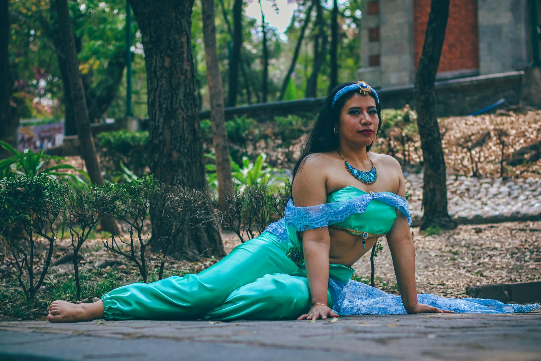 Kobieta w stroju fantazyjnej księżniczki pozuje w zalesionym parku