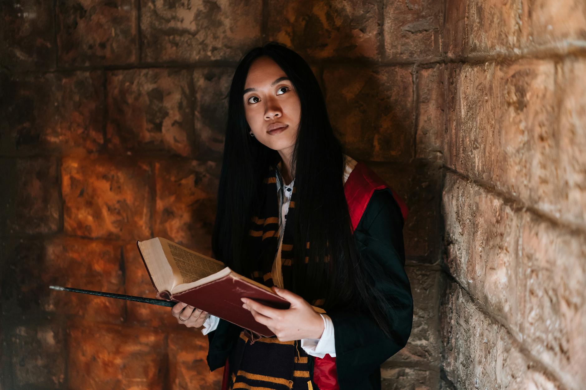 Kobieta w stroju czarodziejki trzymająca księgę zaklęć