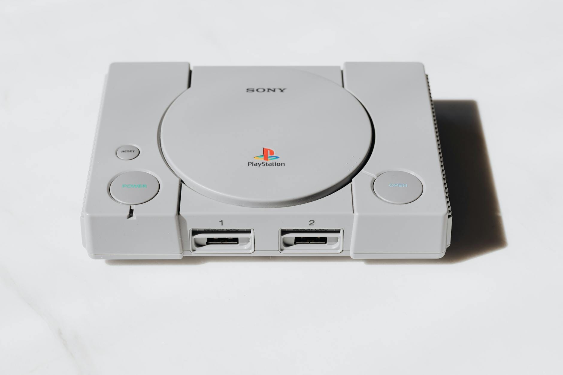 Klasyczna konsola Sony PlayStation na białym tle nawiązuje do retro grania
