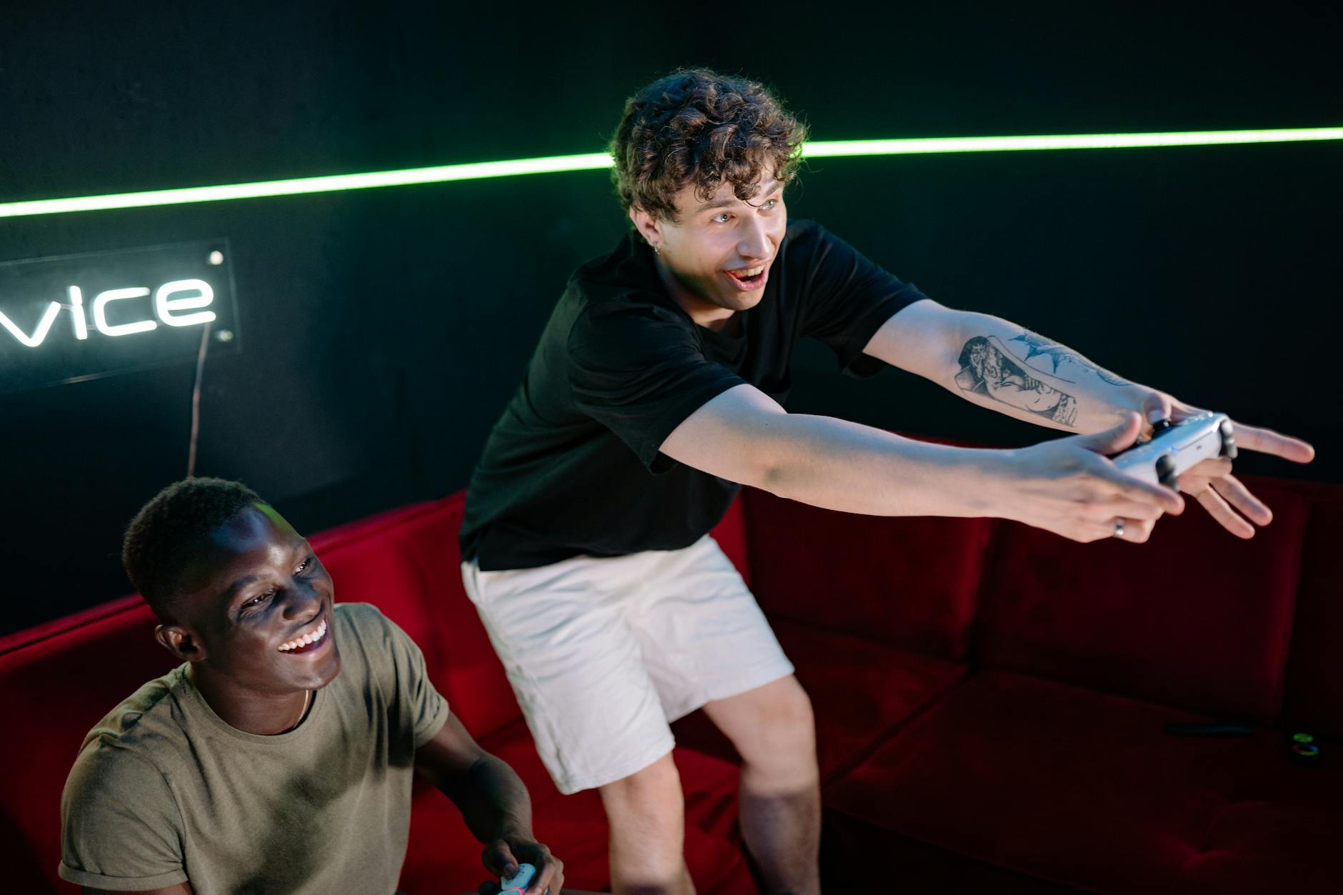 Dwóch młodych mężczyzn gra w gry wideo w przytulnym pokoju